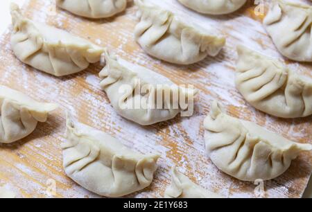 Gyoza cru. Prêt à cuire. Version japonaise des boulettes. Faible profondeur de champ. Banque D'Images