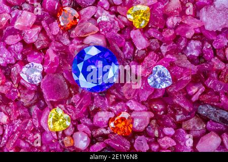 Les diamants de saphir bleu sont placés dans une enclave de diamants en forme de coeur coloré sur des grenats rouges naturels en pierre. Banque D'Images