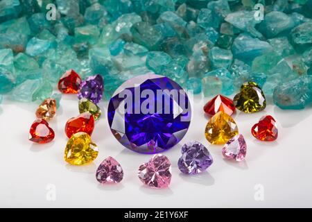 Les diamants bleu saphir sont placés dans une enclave de diamants colorés en forme de coeur sur des pierres précieuses bleu ciel brutes. Bijoux en forme de coeur sont un joli cadeau Banque D'Images