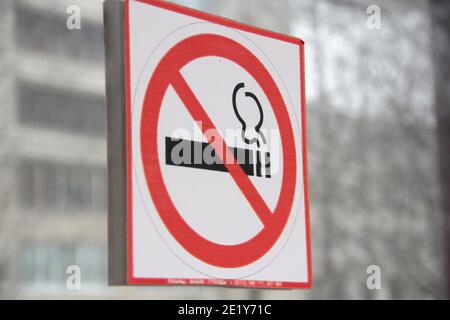 Panneau de non-fumeurs sur porte en verre, concept de soins de santé, renoncement au tabac. Fumer de la cigarette dans un cercle rouge barré. Photo de stock avec espace vide Banque D'Images