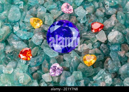 Les diamants bleu saphir sont placés dans une enclave de diamants colorés en forme de coeur sur des pierres précieuses bleu ciel brutes. Bijoux en forme de coeur sont un joli cadeau Banque D'Images