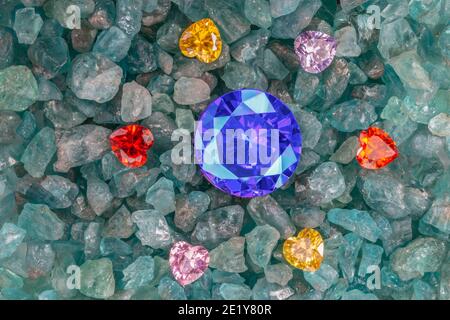 Les diamants bleu saphir sont placés dans une enclave de diamants colorés en forme de coeur sur des pierres précieuses bleu ciel brutes. Bijoux en forme de coeur sont un joli cadeau Banque D'Images