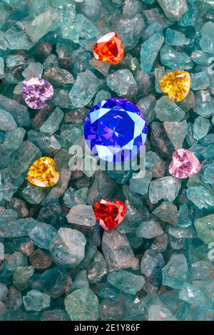 Les diamants bleu saphir sont placés dans une enclave de diamants colorés en forme de coeur sur des pierres précieuses bleu ciel brutes. Bijoux en forme de coeur sont un joli cadeau Banque D'Images