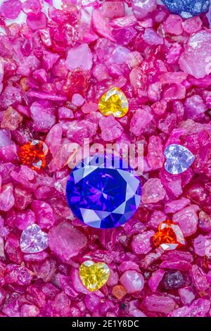 Les diamants de saphir bleu sont placés dans une enclave de diamants en forme de coeur coloré sur des grenats rouges naturels en pierre. Banque D'Images