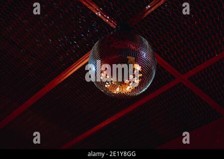 boule disco avec miroir fixée au plafond rouge. discothèque Banque D'Images