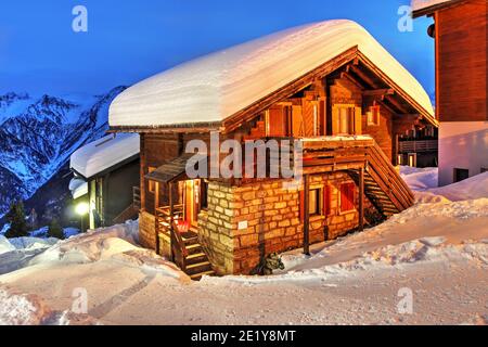 Un chalet pittoresque dans les Alpes suisses la nuit sous une neige abondante. Ce village particulier est Bettmeralp dans le canton du Valais (Wallis), Suisse. Banque D'Images