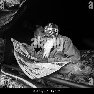 PORTRAIT D'UN MANIFESTANT D'AGRICULTEURS LISANT UN ARTICLE À LA FRONTIÈRE DE DELHI , ILS PROTESTENT CONTRE LA NOUVELLE LOI AGRICOLE ADOPTÉE PAR LE GOUVERNEMENT INDIEN. Banque D'Images