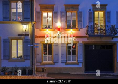 Trois bougies comme éclairage ornent la façade d'un beau Maison historique à Murten (ou Morat en français) Dans le canton de Fribourg en Suisse pendant Banque D'Images