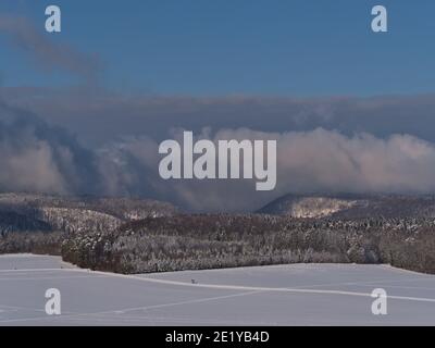 Belle vue aérienne du bord de la chaîne de montagnes Swabian Alb de Kornbühl colline, Burladingen, Allemagne en hiver avec des pistes sur les champs blancs. Banque D'Images