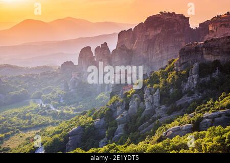 Meteora, Grèce. Formations rocheuses de grès, les monastères Rousanou, Nikolaos et Grand Meteora au coucher du soleil. Banque D'Images