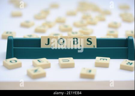 Carreaux Scrabble disposés pour écrire le mot Jobs. Banque D'Images