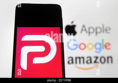 Dans cette illustration, le logo Parler affiché sur un smartphone avec les logos Google, Amazon et Apple affichés sur l'écran du PC en arrière-plan.Google, Apple et Amazon ont suspendu l'application de réseau social Parler. Parler est devenu indisponible dans l'App Store, Google Play et Amazon Web Services, apparemment comme indiqué un contrôle insuffisant sur les publications des utilisateurs qui encourageaient la violence, semble-t-il par les médias. Banque D'Images