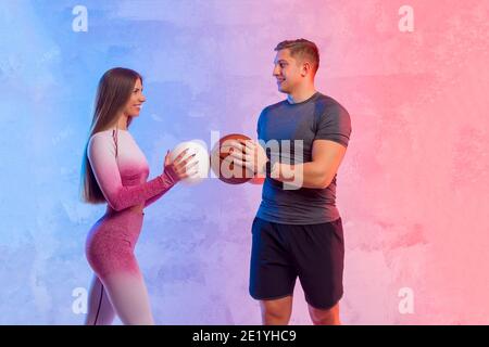 Les athlètes hommes et femmes s'entraînent avec le volley-ball et le ballon de basket-ball. Concept de formations personnelles Banque D'Images