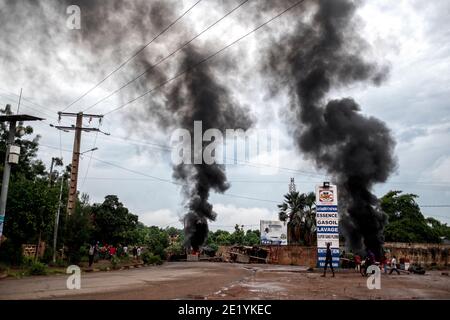 De la fumée est vue s'enlisant des barrages routiers mis en place par les manifestants lors des émeutes violentes à Bamako, Mali, le 11 juillet 2020 Banque D'Images