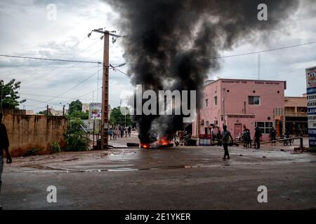 De la fumée est vue s'enlisant des barrages routiers mis en place par les manifestants lors des émeutes violentes à Bamako, Mali, le 11 juillet 2020 Banque D'Images