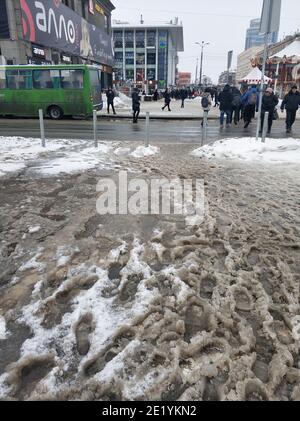 Porridge of snow and grease on the road. Uncleared city roads in winter. Stock Photo