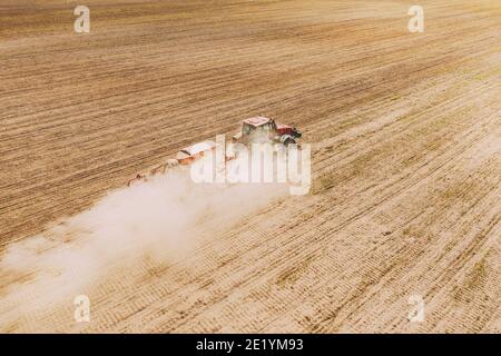 Vue aérienne. Tracteur avec semoir semis semis des semences pour les récoltes en saison de printemps. Début de la saison agricole du printemps. Campagne rurale Banque D'Images