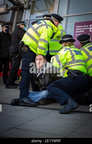 Un manifestant est arrêté par la police sur Clapham High Street lors de la manifestation anti-verrouillage le 9 janvier 2021 à Londres, en Angleterre Banque D'Images