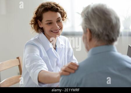 Heureux jeune 30s médecin médecin médecin soutenant patient âgé. Banque D'Images