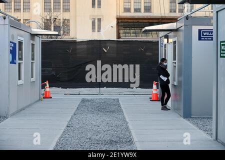 Une femme se tient à une fenêtre à l'intérieur du site de vaccination de l'hôpital NYCHealth situé à l'extérieur du terminal de l'armée de Brooklyn, dans le quartier de Brooklyn, New York, le 10 janvier 2021. Le 11 janvier, la ville de New York activera cinq points de vaccination prioritaires dans le groupe 1B, qui comprend les travailleurs de la santé, les travailleurs de l'éducation, les premiers intervenants, les travailleurs de la sécurité publique, les travailleurs des transports en commun et les quelque 1.4 millions de personnes âgées de 75 ans et plus. Le site DE LA CHAUVE-SOURIS sera équipé de 27 membres du personnel de vaccination dans le but de donner chacun 5 doses de vaccin COVID-19 par heure. (Photo par un Banque D'Images