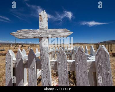 Une tombe clôturée avec une croix en bois à un cimetière sur la route 66 au Nouveau-Mexique. Banque D'Images