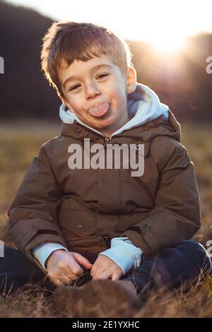 Portrait d'un mignon petit garçon qui colle de sa langue Banque D'Images