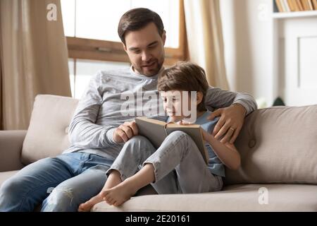 Un père heureux et un petit fils ont lu le livre à la maison Banque D'Images