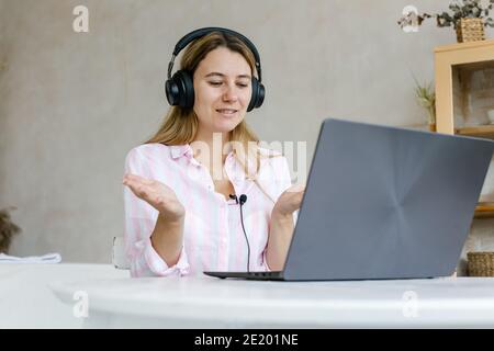 Engagé dans l'entraînement à distance. Une jeune femme active travaillant à distance participe à une réunion virtuelle à l'aide d'un ordinateur à domicile. Une étudiante de sexe féminin participe à la vidéo co Banque D'Images