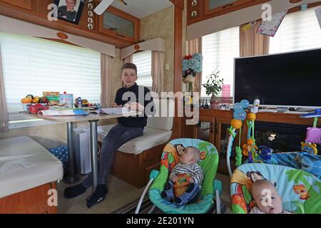 Royaume-Uni / Newport Pagnell / Pinders Circus / Boy faisant ses devoirs en caravane. Banque D'Images