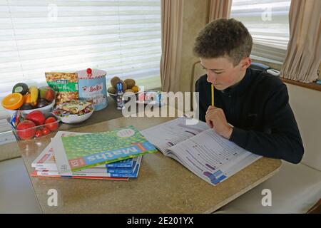 Royaume-Uni / Newport Pagnell / Pinders Circus / Boy faisant ses devoirs en caravane. Banque D'Images