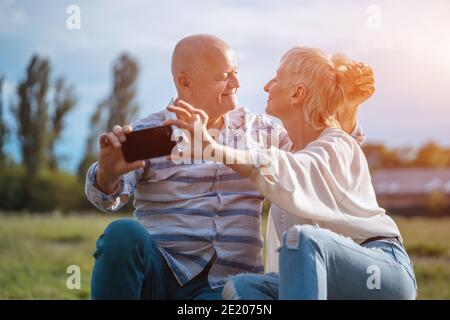 joyeux couple senior datant, prenant le selfie et s'amuser en plein air Banque D'Images