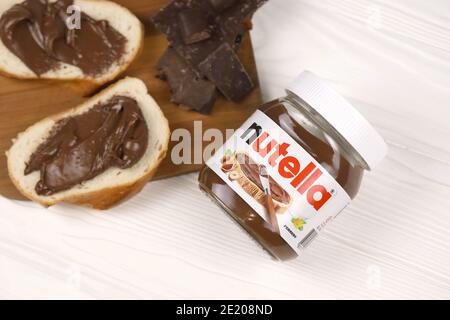 KHARKOV, UKRAINE - 27 DÉCEMBRE 2020 : le verre de Nutella peut et tartiner sur du pain frais. Nutella est fabriqué par la société italienne Ferrero firs Banque D'Images