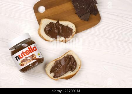 KHARKOV, UKRAINE - 27 DÉCEMBRE 2020 : le verre de Nutella peut et tartiner sur du pain frais. Nutella est fabriqué par la société italienne Ferrero firs Banque D'Images