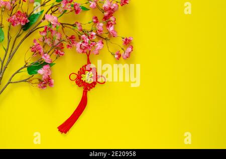 Pendentif suspendu pour ornement du nouvel an chinois (sens du mot est richesse) avec fleurs chinoises sur fond jaune. Banque D'Images