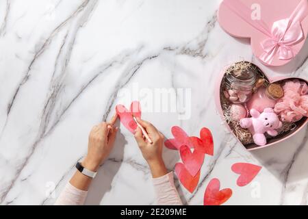 Vue sur le dessus des boîtes-cadeaux en forme de coeur de couleur rose avec fournitures de bain faites maison, bonbons guimauves Banque D'Images