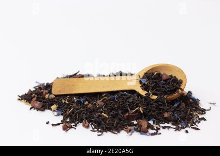 Pile de thé en feuilles avec cuillère de service en bois. Banque D'Images