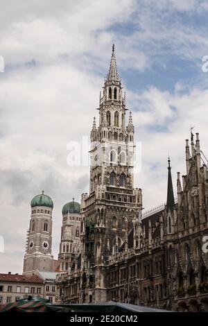 Le Neues Rathaus (nouvel hôtel de ville) sur Marienplatz à Munich, Allemagne. Les deux dômes de la Frauenkirche sont visibles derrière elle. Banque D'Images