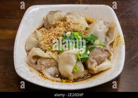 Gros plan de la cuisine taïwanaise traditionnelle taïwanaise épicée à la vapeur sur une vieille table en bois au restaurant Food Night Market à Taipei, Taïwan. Banque D'Images