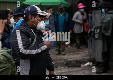 La Paz, Bolivie. 08 janvier 2021. Un homme fait face à la police anti-émeute bolivienne qui bloque l'accès à la construction de l'association régionale des producteurs de feuilles de coca (ADEPCOCA). Depuis des années, il y a eu un conflit entre les différents groupes qui tentent de contrôler ADEPCOCA. La situation s'est aggravée après la crise politique de novembre 2019, conduisant à des combats répétés. La production de Coca est légale en Bolivie et les feuilles trouvent une variété d'utilisations. Credit: Radoslaw Czajkowski/dpa/Alay Live News Banque D'Images