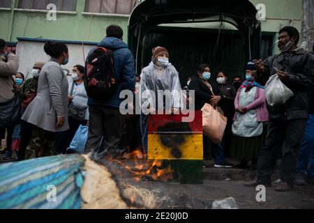 La Paz, Bolivie. 08 janvier 2021. Une femme se tient à l'entrée du bâtiment de l'association régionale des producteurs de feuilles de coca (ADEPCOCA) avec un panneau maison décoré du drapeau bolivien. Depuis des années, il y a eu un conflit entre les différents groupes qui tentent de contrôler ADEPCOCA. La situation s'est aggravée après la crise politique de novembre 2019, conduisant à des combats répétés. La production de Coca est légale en Bolivie et les feuilles trouvent une variété d'utilisations. Credit: Radoslaw Czajkowski/dpa/Alay Live News Banque D'Images