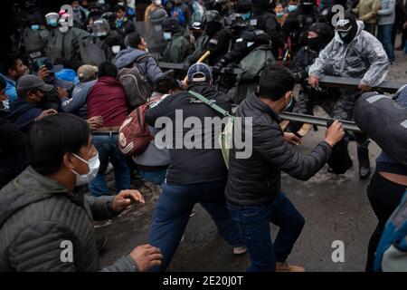 La Paz, Bolivie. 08 janvier 2021. Les hommes tentent de forcer leur chemin dans la construction de l'association régionale des producteurs de feuilles de coca (ADEPCOCA). La police anti-émeute bolivienne protège le bâtiment. Depuis des années, il y a eu un conflit entre les différents groupes qui tentent de contrôler ADEPCOCA. La situation s'est aggravée après la crise politique de novembre 2019, conduisant à des combats répétés. La production de Coca est légale en Bolivie et les feuilles trouvent une variété d'utilisations. Credit: Radoslaw Czajkowski/dpa/Alay Live News Banque D'Images