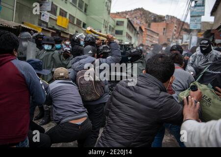 La Paz, Bolivie. 08 janvier 2021. Les hommes tentent de forcer leur chemin dans la construction de l'association régionale des producteurs de feuilles de coca (ADEPCOCA). La police anti-émeute bolivienne protège le bâtiment. Depuis des années, il y a eu un conflit entre les différents groupes qui tentent de contrôler ADEPCOCA. La situation s'est aggravée après la crise politique de novembre 2019, conduisant à des combats répétés. La production de Coca est légale en Bolivie et les feuilles trouvent une variété d'utilisations. Credit: Radoslaw Czajkowski/dpa/Alay Live News Banque D'Images