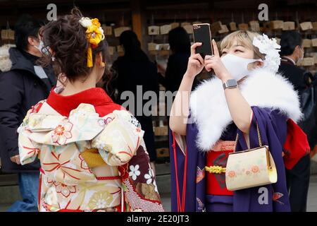 Tokyo, Japon. 11 janvier 2021. Les filles japonaises vêtues de kimonos colorés prennent des photos les unes des autres au sanctuaire Meiji pendant le prochain jour de l'âge. Le jour de l'âge à venir (Seijin-no-Hi) est une fête pour féliciter et encourager tous ceux qui sont devenus adultes (20 ans) au Japon. La célébration annuelle a lieu le deuxième lundi de janvier, bien que de nombreux événements habituellement jubilants aient été annulés au sujet des craintes du coronavirus. Credit: Rodrigo Reyes Marin/ZUMA Wire/Alay Live News Banque D'Images