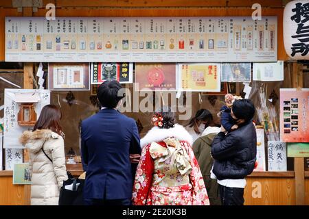 Tokyo, Japon. 11 janvier 2021. Les visiteurs s'alignent pour acheter des charmes chanceux au sanctuaire Meiji pendant la prochaine journée de l'âge. Le jour de l'âge à venir (Seijin-no-Hi) est une fête pour féliciter et encourager tous ceux qui sont devenus adultes (20 ans) au Japon. La célébration annuelle a lieu le deuxième lundi de janvier, bien que de nombreux événements habituellement jubilants aient été annulés au sujet des craintes du coronavirus. Credit: Rodrigo Reyes Marin/ZUMA Wire/Alay Live News Banque D'Images