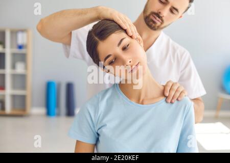 Homme médecin chiropracteur ou ostéopathe fixant les articulations du cou des womans avec mains pendant la visite et le traitement Banque D'Images