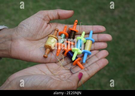 Collection de bobines miniatures, rouleaux de fil appelés Manjha ou maanja dans les paumes de main. Jouet spools manja à l'occasion du festival de cerf-volant uttara Banque D'Images