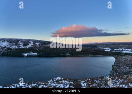 Magnifique coucher de soleil au-dessus de la crête enneigée près du pic d'Eagles Crag et du lac Lough Bray Lower dans des tons froids d'hiver, Co. Wicklow, Irlande. Hiver Irlande Banque D'Images