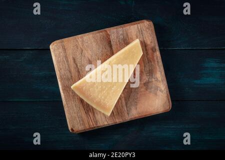 Parmesan, tiré du dessus sur fond bleu foncé Banque D'Images