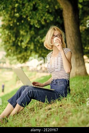 Fille ordinateur portable à l'extérieur. Être à l'extérieur expose les travailleurs à l'air frais et les variations environnementales rendant heureux et en bonne santé sur le plan physique et émotionnel. Pourquoi les employés doivent-ils travailler à l'extérieur ? Banque D'Images