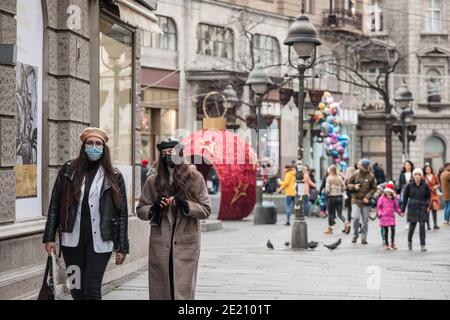 BELGRADE, SERBIE - 12 DÉCEMBRE 2020 : deux filles, jeunes femmes, amis, marchant en hiver en portant un masque respiratoire dans la rue Kneza Mihailova Banque D'Images